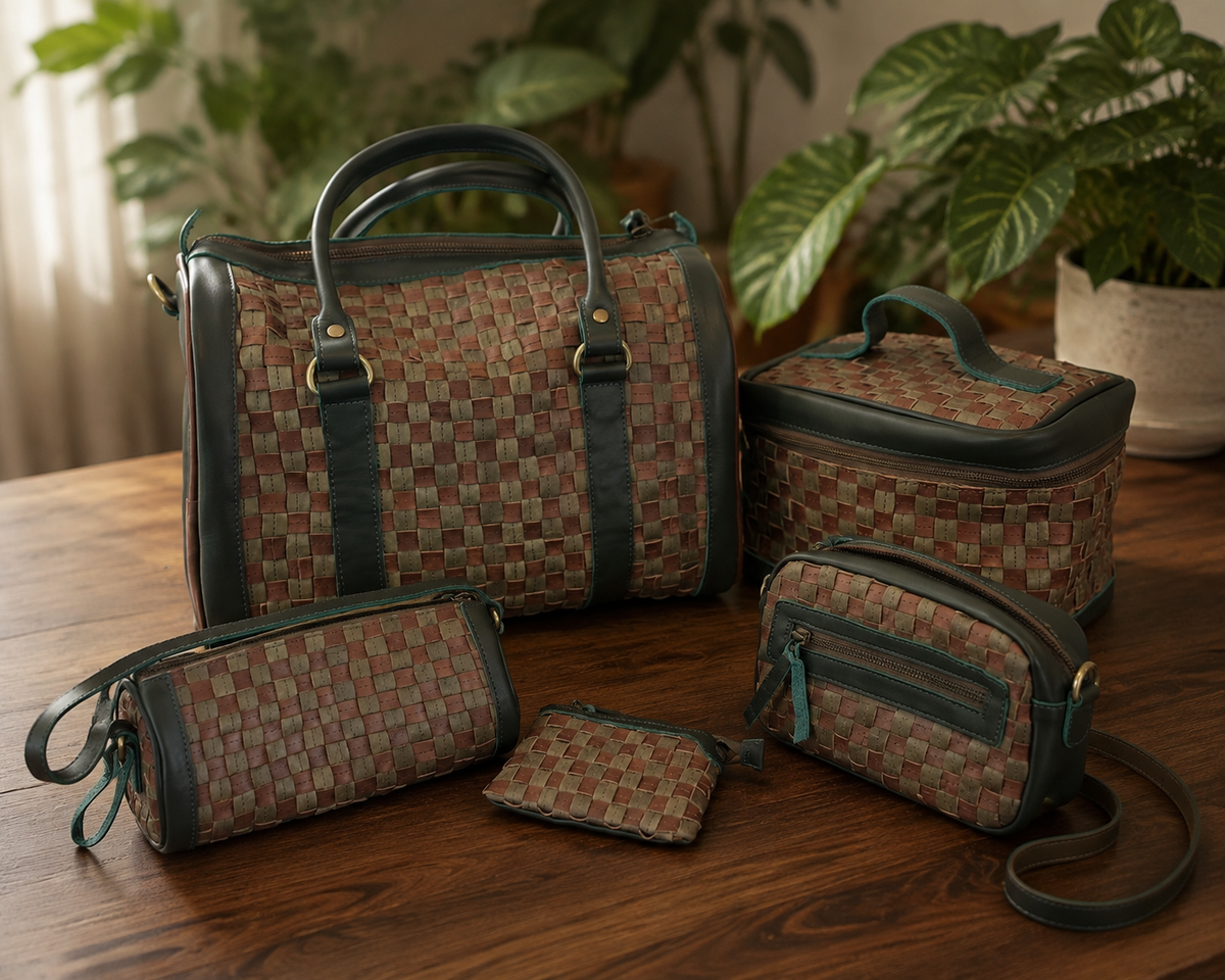 ShopYego Garnet Desert Rose collection flat lay featuring the Bella Crescent Bag, Gode Crossbody, and Shashemene Wallet. Handwoven leather in plum and dusty rose displayed on an olive green picnic blanket with fall leaves, artisan made in Ethiopia.