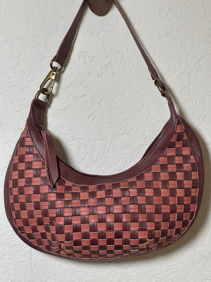 Bella Crescent Shoulder Bag in Garnet Desert Rose — handcrafted in Ethiopia with a handwoven checkered weave in plum purple, dusty rose pink, and deep burgundy upcycled leather. — handcrafted in Ethiopia with a handwoven checkered weave in plum purple, dusty rose pink, and deep burgundy upcycled leather.