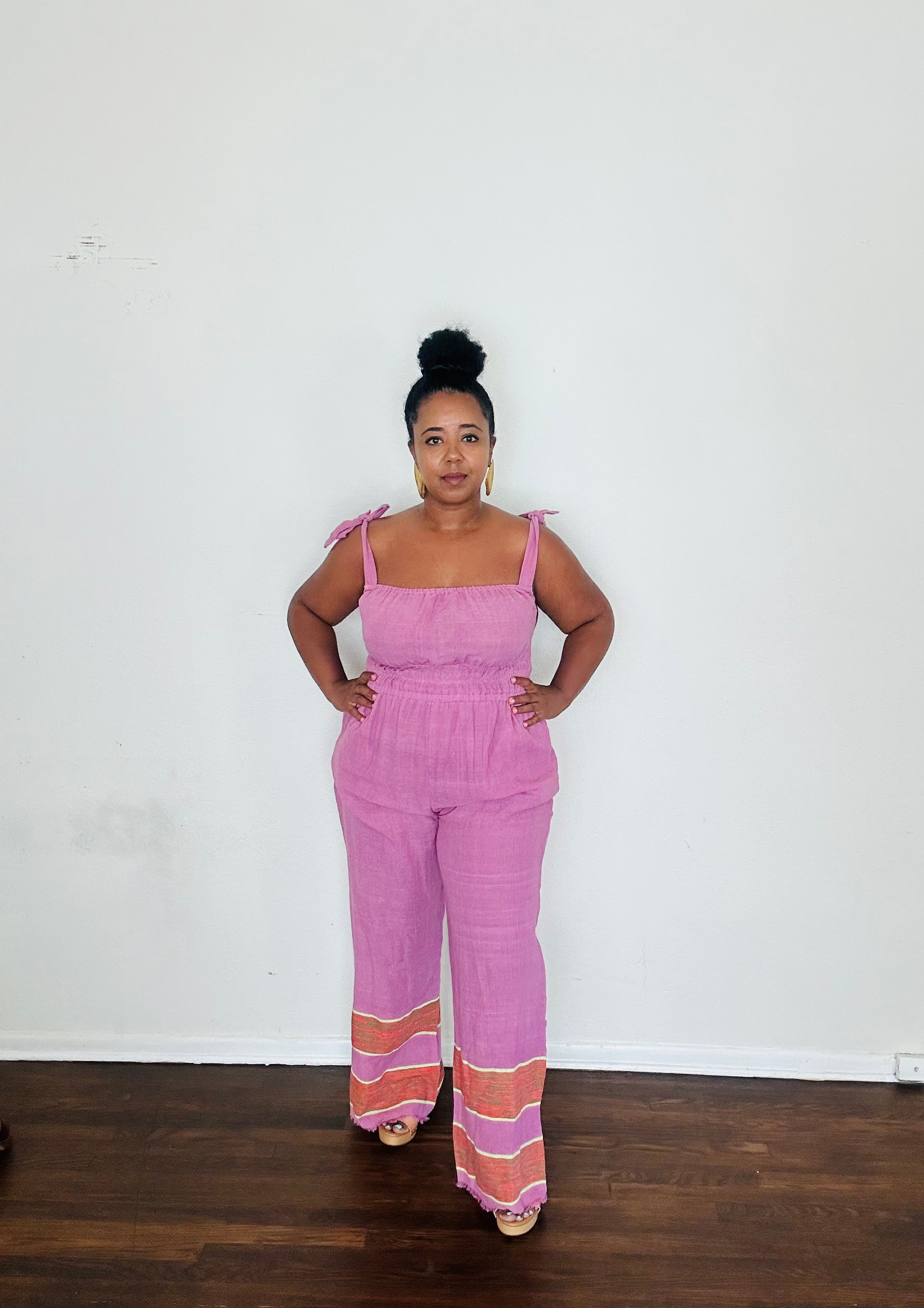 Handmade Lavender  Sebie Jumpsuit in 100% cotton, featuring a flattering waist, adjustable straps, and deep pockets. Finished with a signature brown hem detailed with lime green accents for a bold, free-spirited LA style
