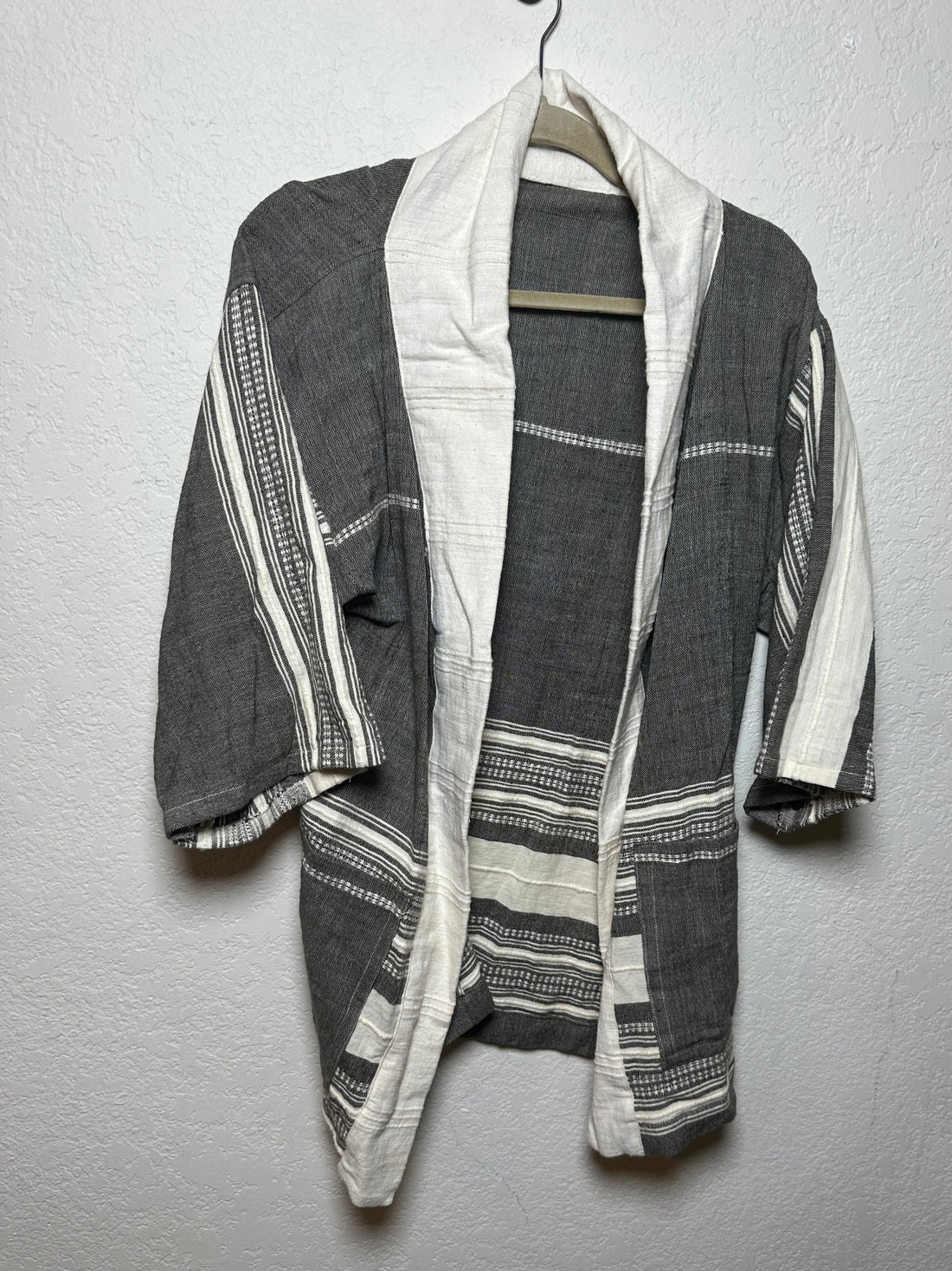 Folded fabric with gray and white stripes on a gray surface
