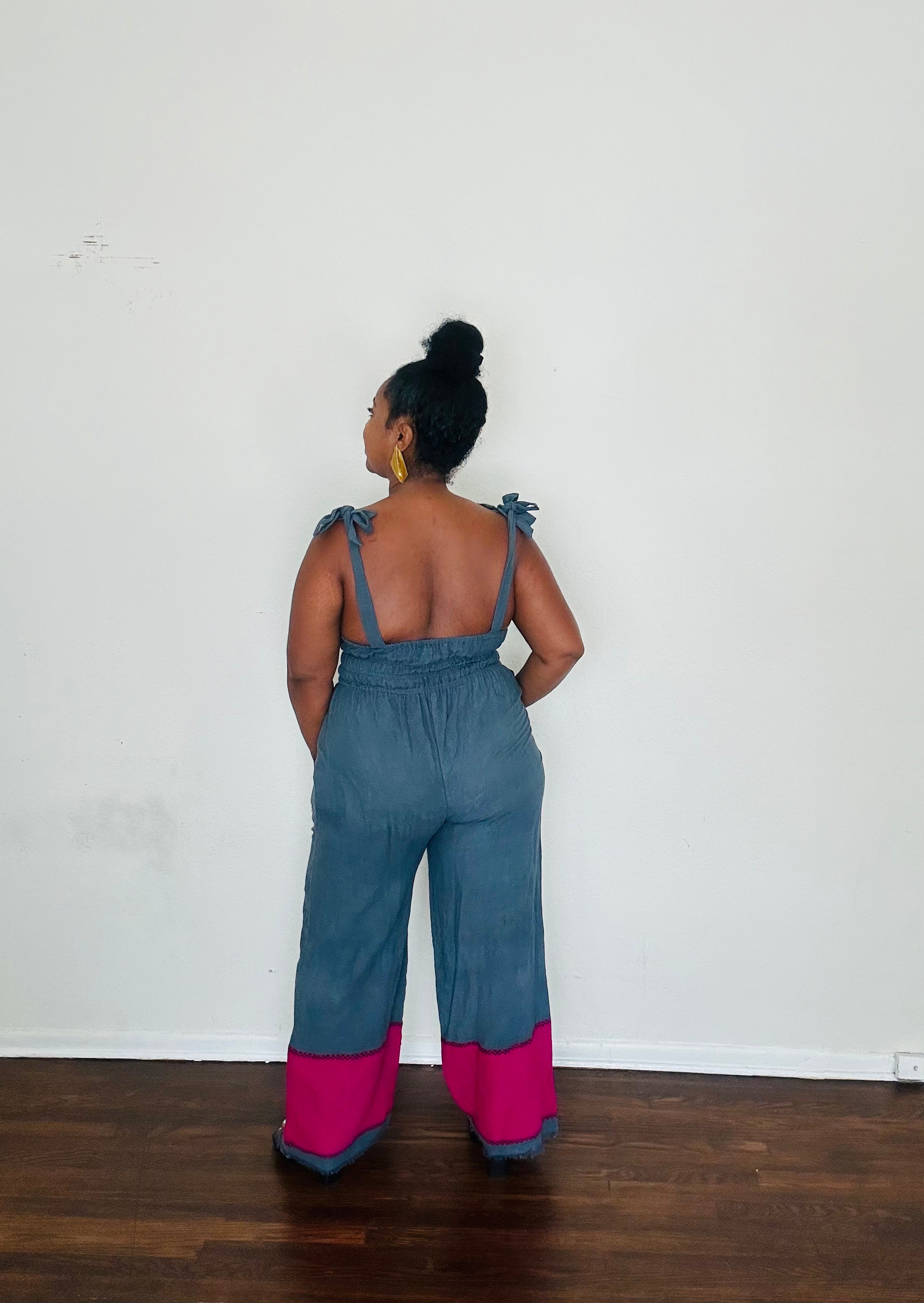 Handmade in Ethiopia from 100% cotton, the Sebie Jumpsuit in Midnight Bloom blends this season’s trending blue slate with a bold fuchsia pink hem for an effortlessly chic statement.