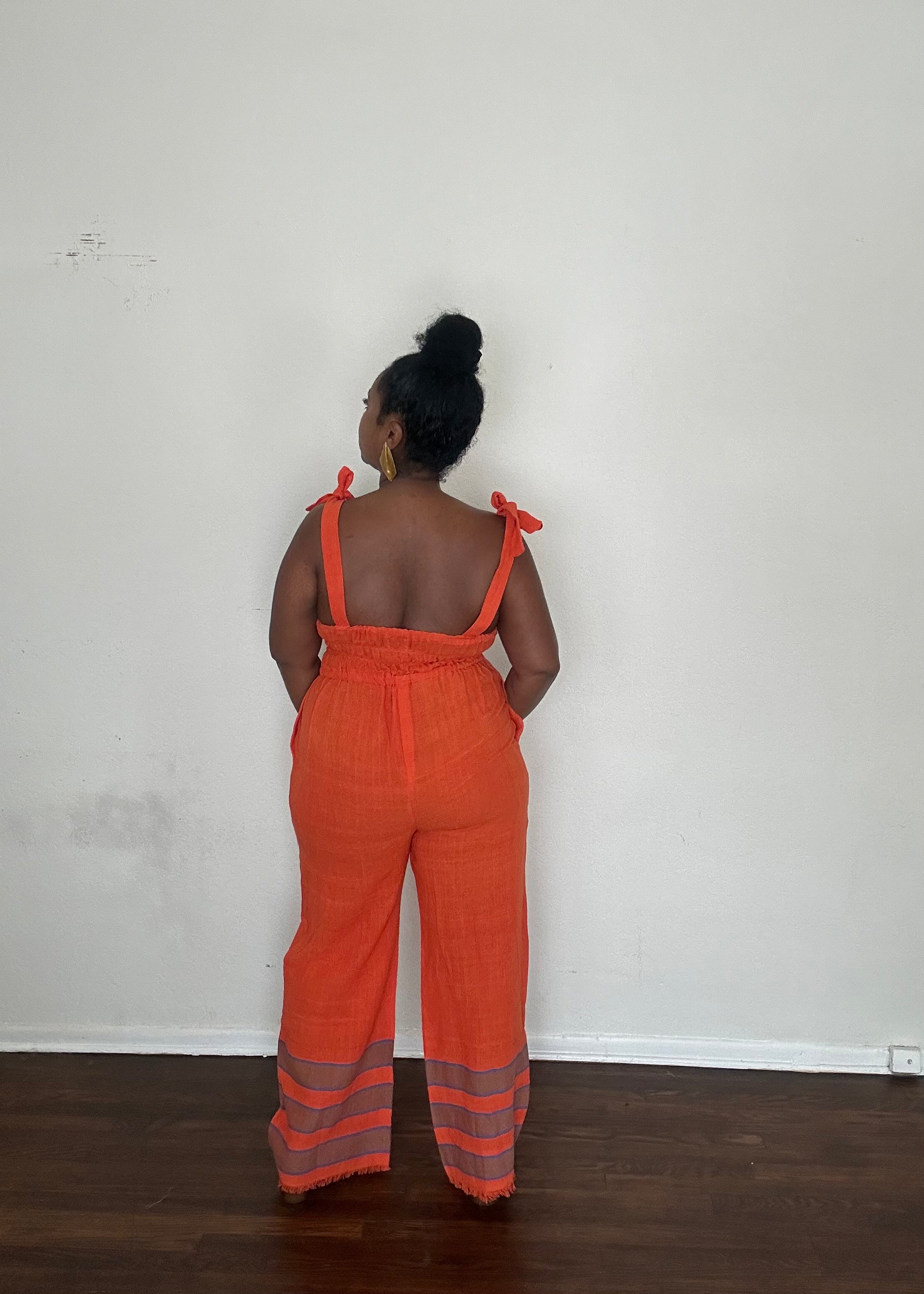 Sebie Jumpsuit in Saffron Flame, a handmade 100% cotton jumpsuit featuring a deep orange-red tone inspired by fall’s burnt sienna trend.