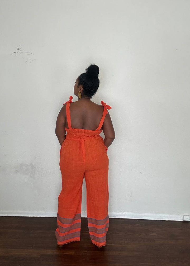 Sebie Jumpsuit in Saffron Flame, a handmade 100% cotton jumpsuit featuring a deep orange-red tone inspired by fall’s burnt sienna trend.
