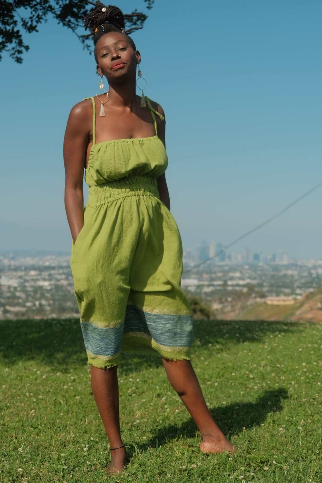 Enani Dress Lime Aura — handmade 100% cotton short dress in lime green with contrasting blue hem, straight neckline, adjustable straps, cinched waist, and hidden pockets.