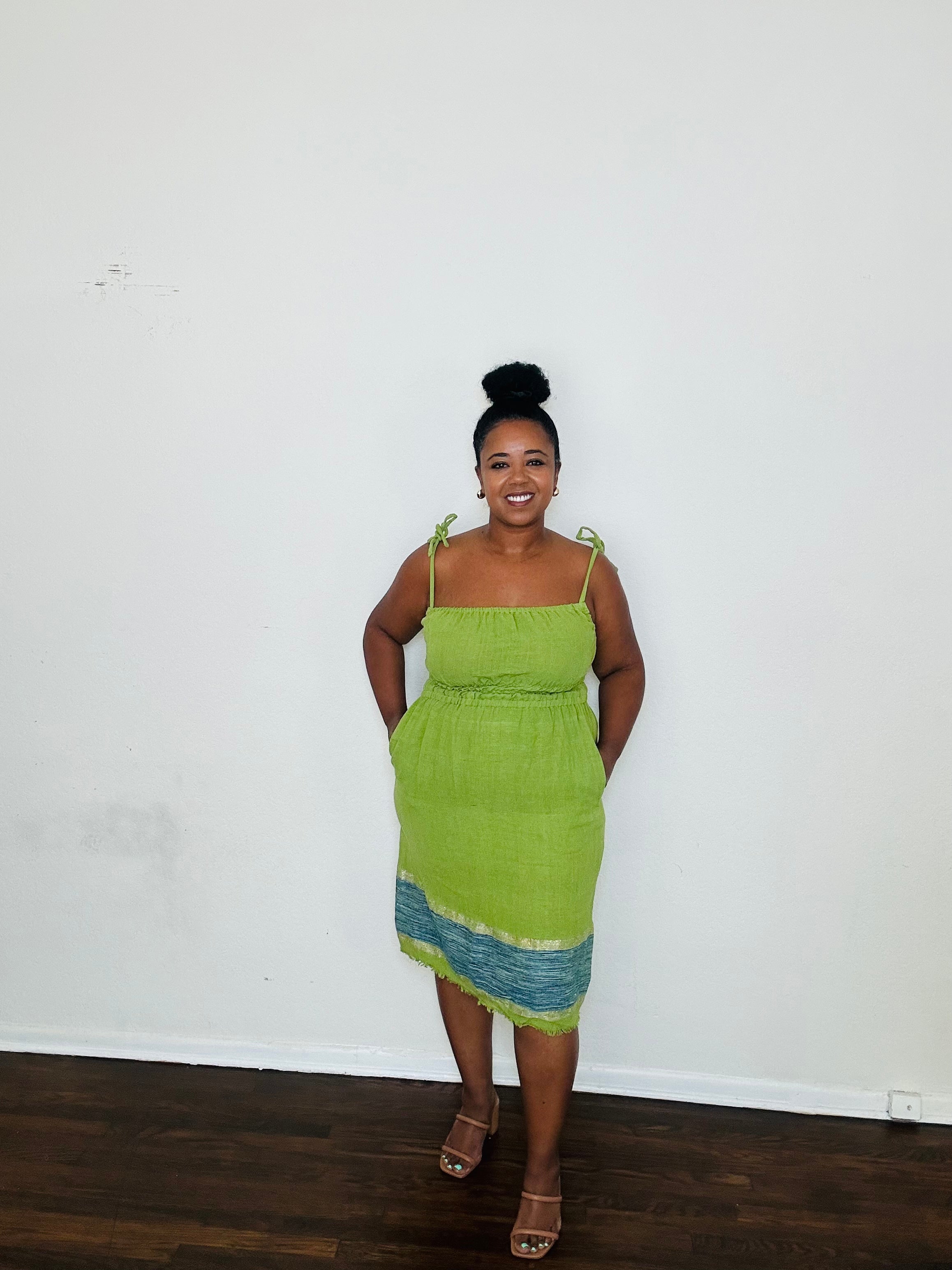 Enani Dress Lime Aura — handmade 100% cotton short dress in lime green with contrasting blue hem, straight neckline, adjustable straps, cinched waist, and hidden pockets.