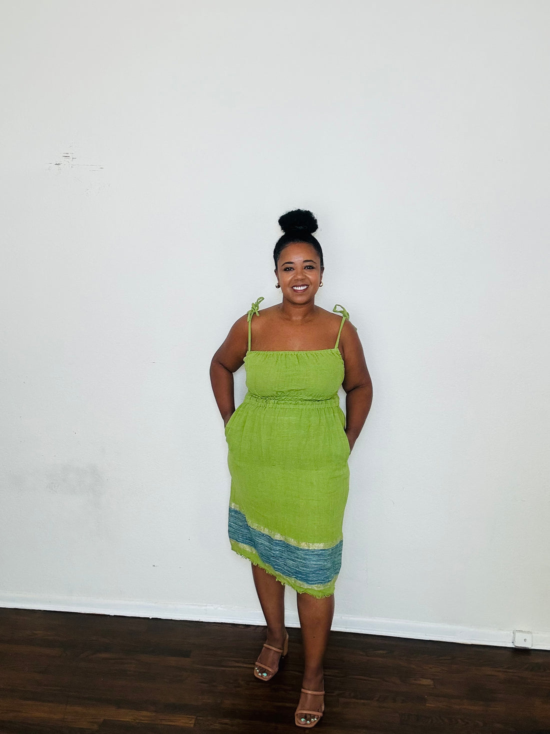 Enani Dress Lime Aura — handmade 100% cotton short dress in lime green with contrasting blue hem, straight neckline, adjustable straps, cinched waist, and hidden pockets.