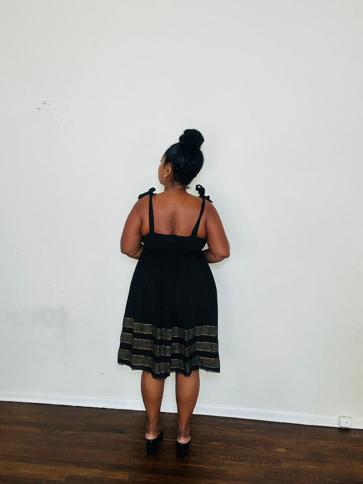 Gelila Dress Obsidian Flow — handmade 100% cotton midi dress with straight neckline, adjustable straps, cinched waist, flowing skirt, and hidden pockets in classic black.
