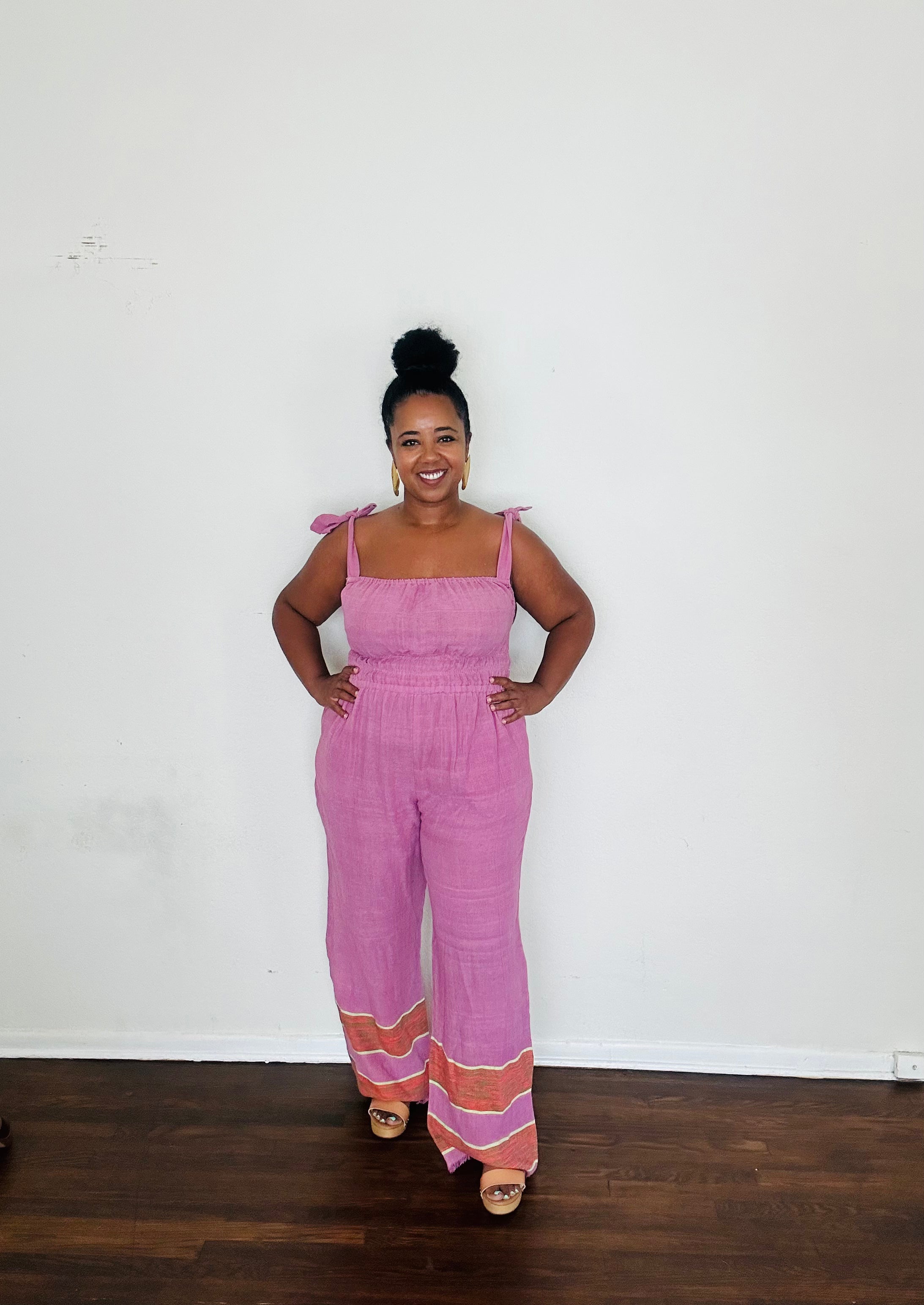 Handmade Lavender Sebie Jumpsuit in 100% cotton, featuring a flattering waist, adjustable straps, and deep pockets. Finished with a signature brown hem detailed with lime green accents for a bold, free-spirited LA style
