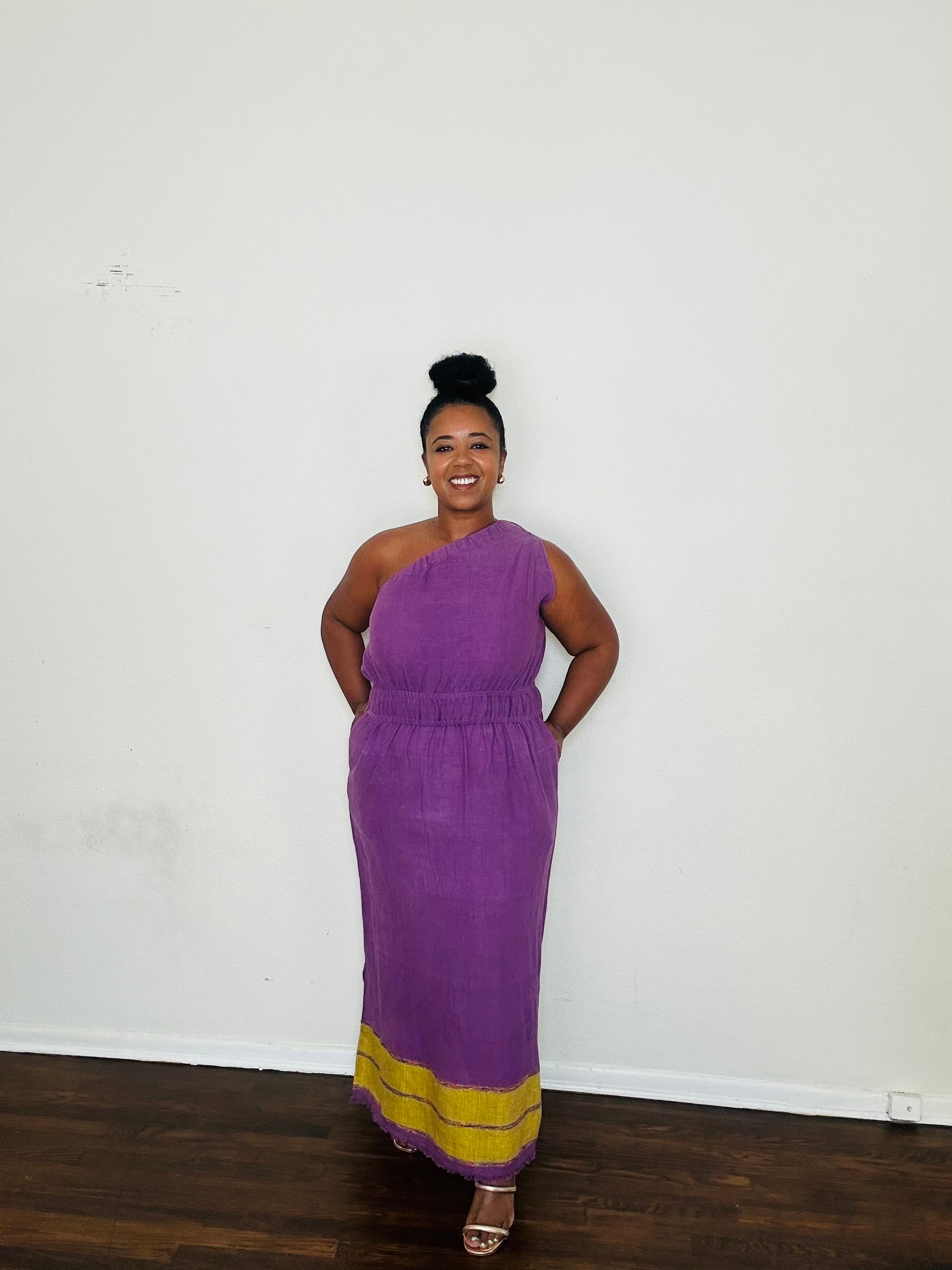 Marye Dress Crown Violet — handmade 100% cotton maxi dress with one-shoulder neckline, cinched waist, flowing A-line silhouette, and side slits in a regal violet tone.