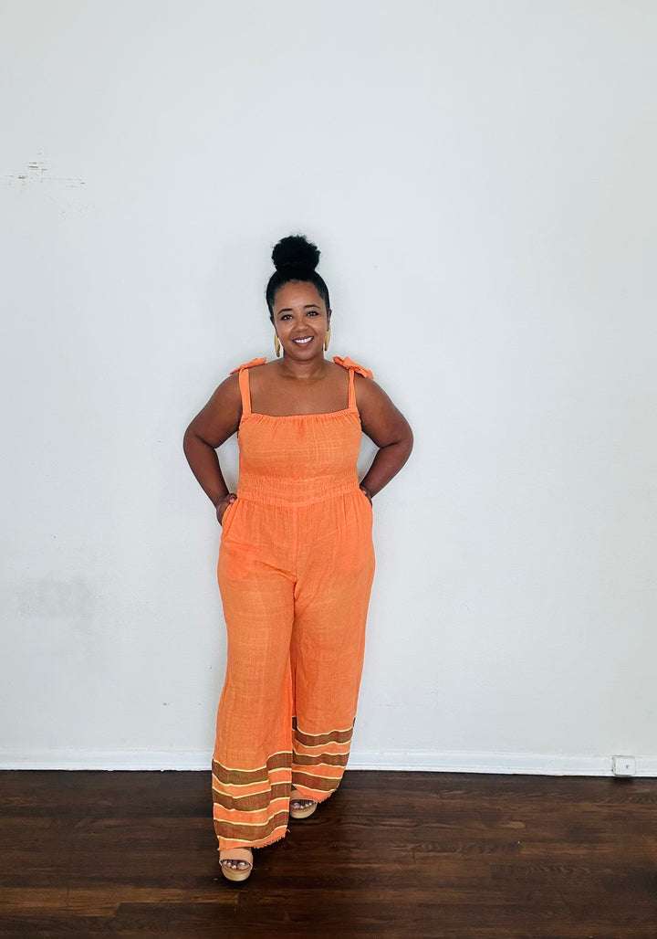 Handmade Orange Tangerine Dream Sebie Jumpsuit in 100% cotton, featuring a flattering waist, adjustable straps, and deep pockets. Finished with a signature brown hem detailed with lime green accents for a bold, free-spirited LA style