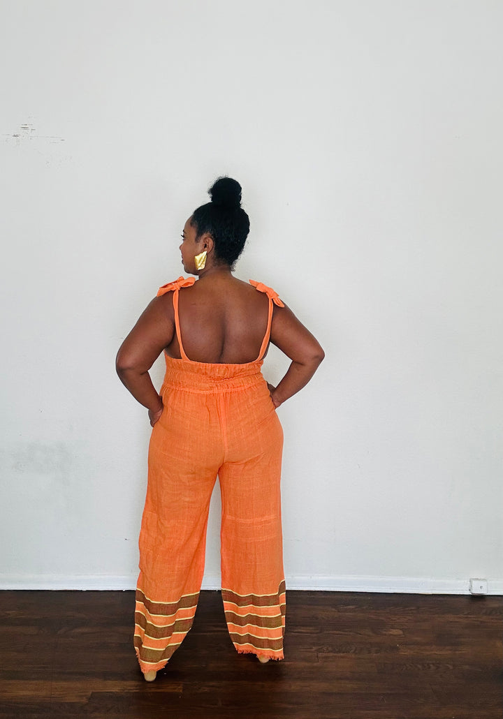 Handmade Orange Tangerine Dream Sebie Jumpsuit in 100% cotton, featuring a flattering waist, adjustable straps, and deep pockets. Finished with a signature brown hem detailed with lime green accents for a bold, free-spirited LA style