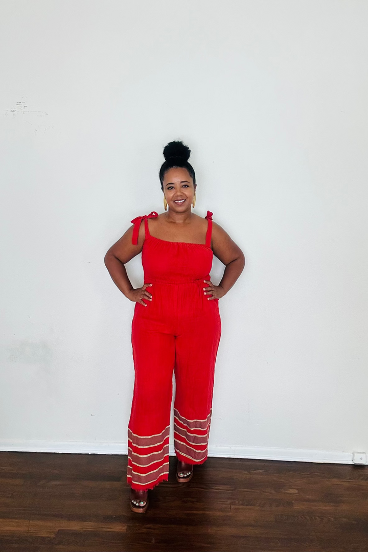 Handmade Cherry Red Sebie Jumpsuit in 100% cotton, featuring a flattering waist, adjustable straps, and deep pockets. Finished with a signature brown hem detailed with lime green accents for a bold, free-spirited LA style