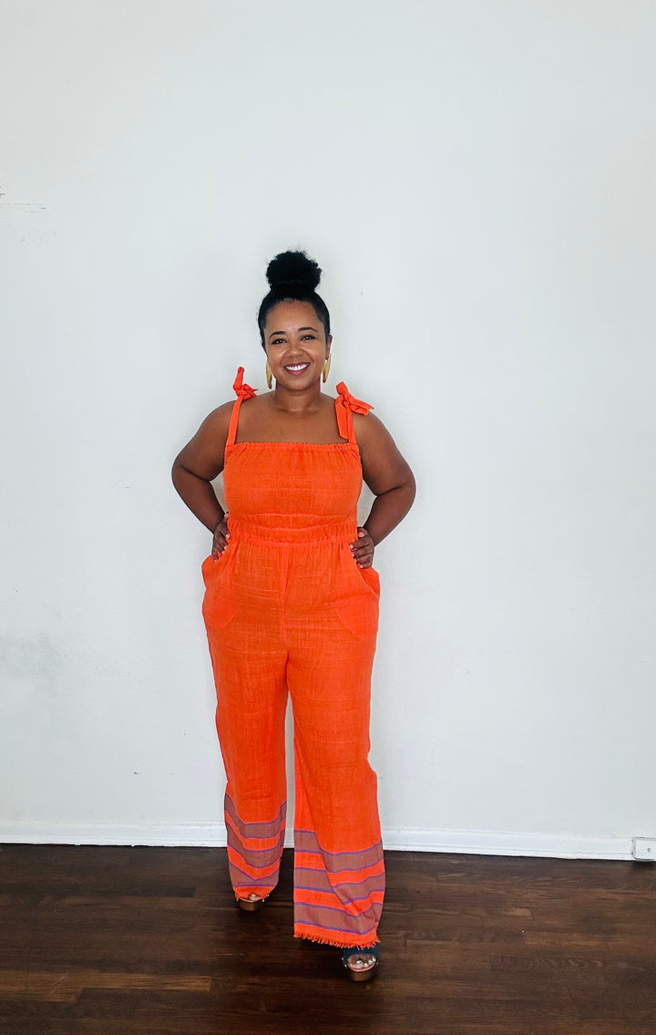 Sebie Jumpsuit in Saffron Flame, a handmade 100% cotton jumpsuit featuring a deep orange-red tone inspired by fall’s burnt sienna trend.