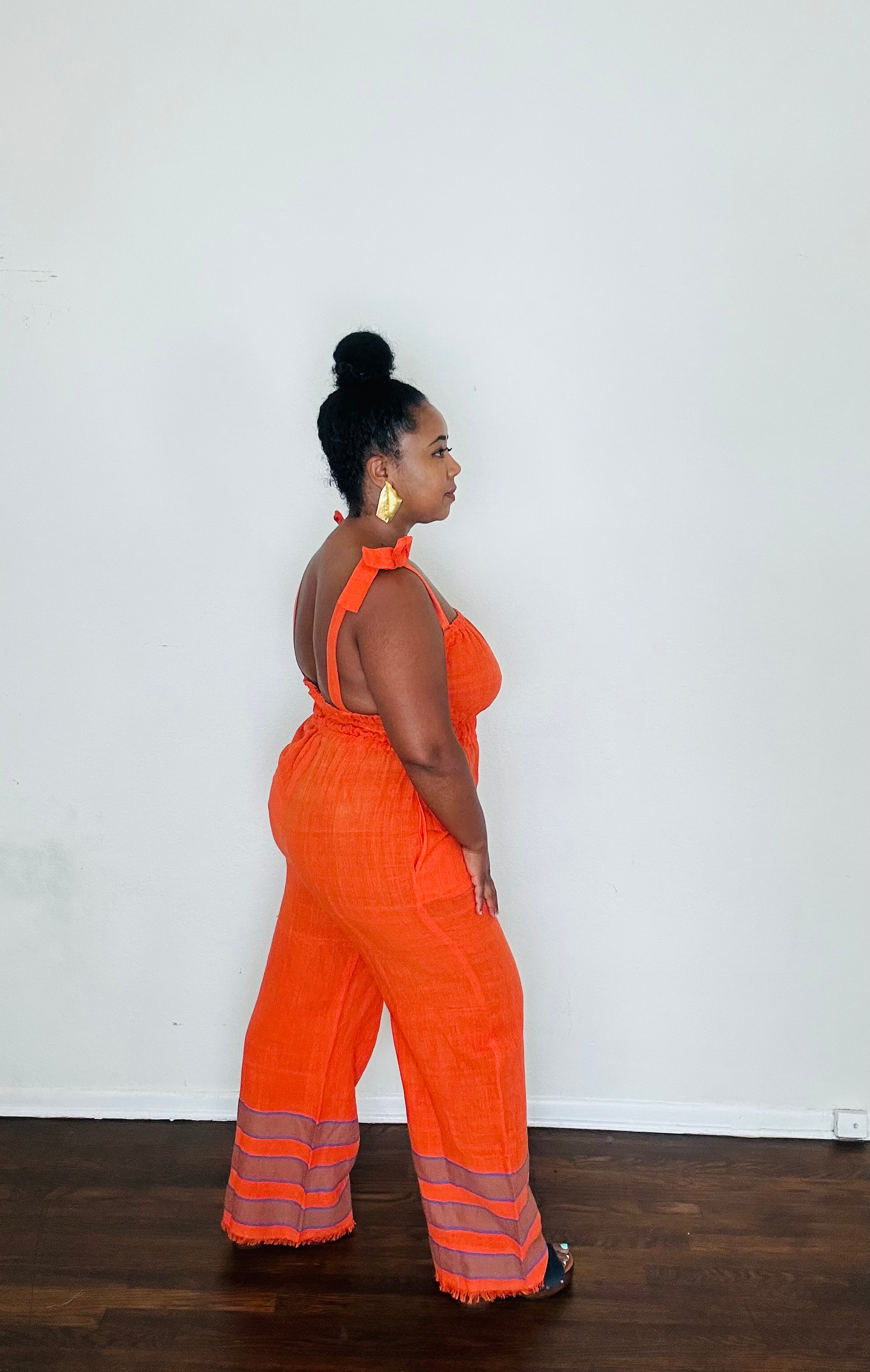 Sebie Jumpsuit in Saffron Flame, a handmade 100% cotton jumpsuit featuring a deep orange-red tone inspired by fall’s burnt sienna trend.