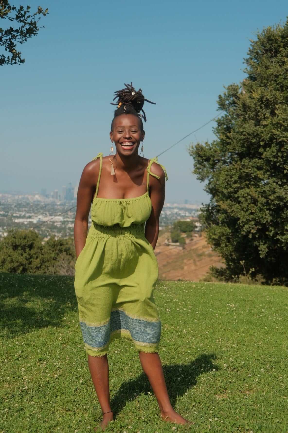 Enani Dress Lime Aura — handmade 100% cotton short dress in lime green with contrasting blue hem, straight neckline, adjustable straps, cinched waist, and hidden pockets.